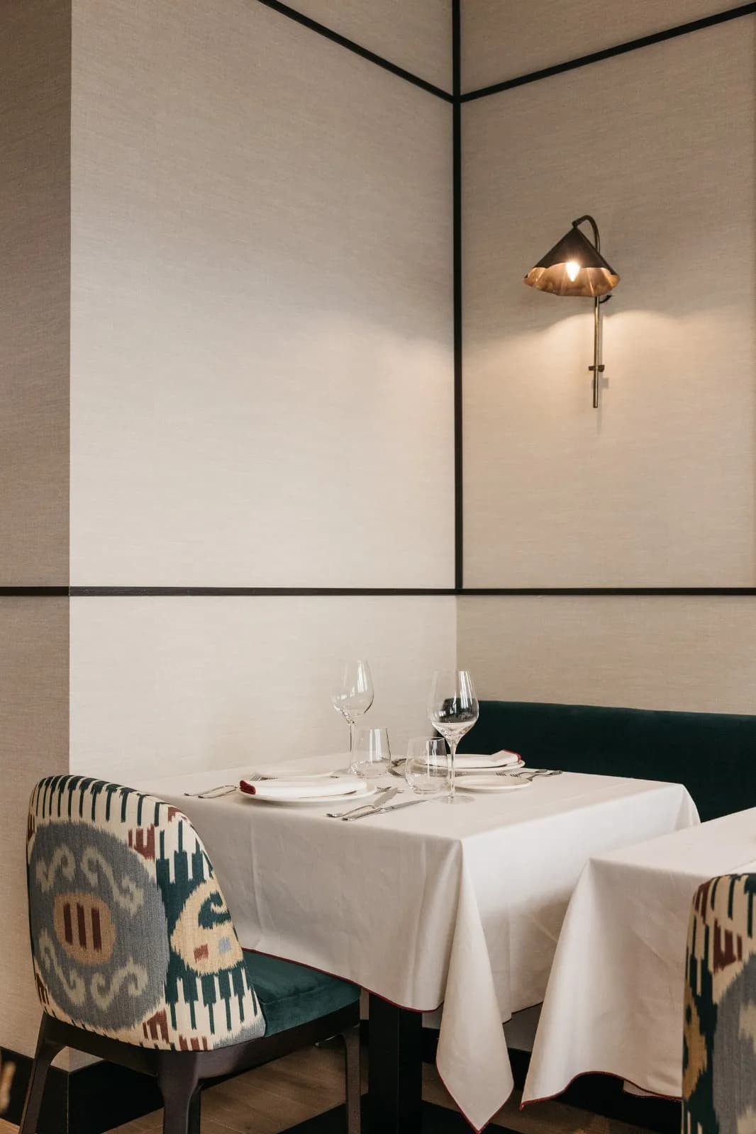 Mesa puesta con copa y aplique en rincón íntimo