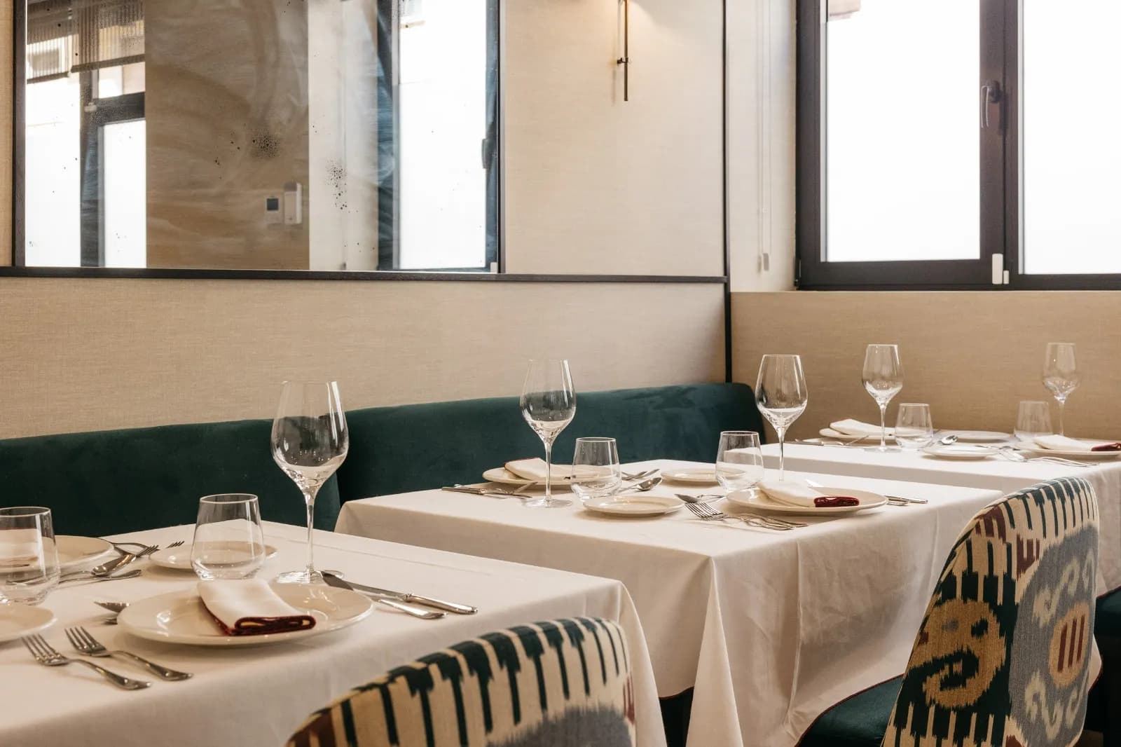 Mesas puestas junto a ventanales y espejo